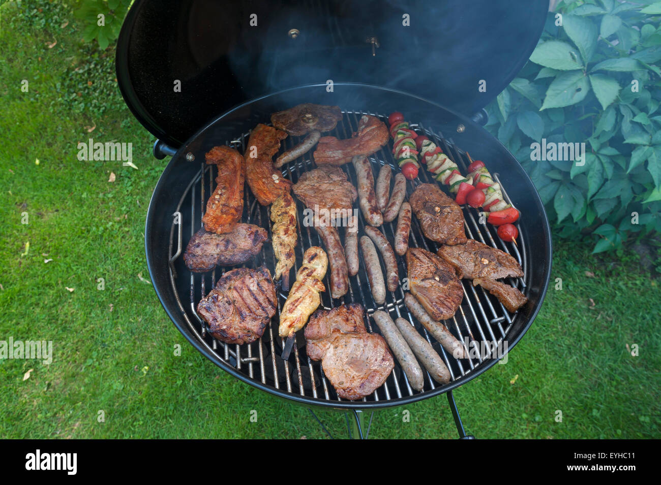 Viande, saucisses et brochettes végétariennes sur un barbecue au charbon de bois Banque D'Images
