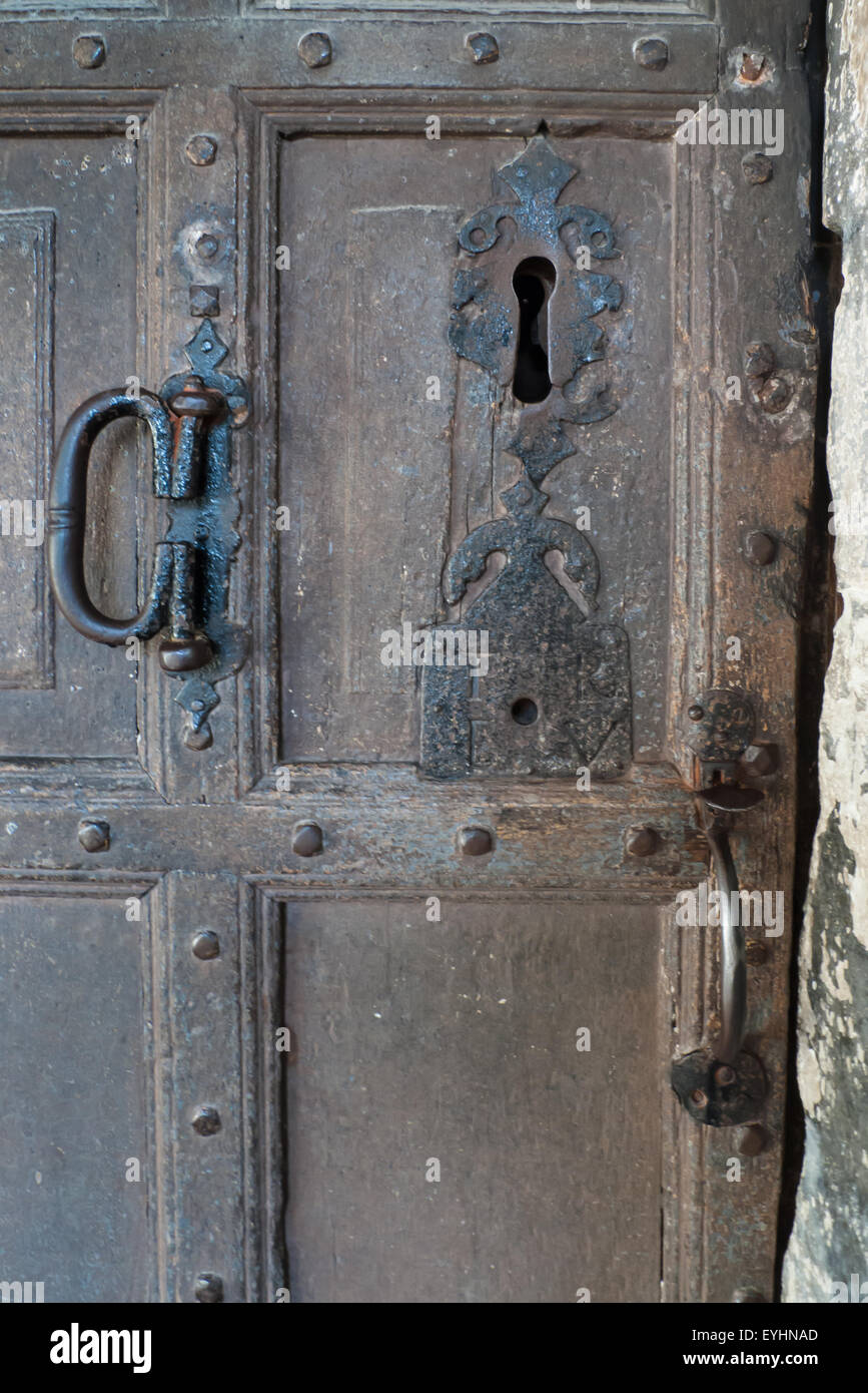 L'Angleterre. Vieille porte en bois avec de grandes keyhole et poignées en métal. Banque D'Images