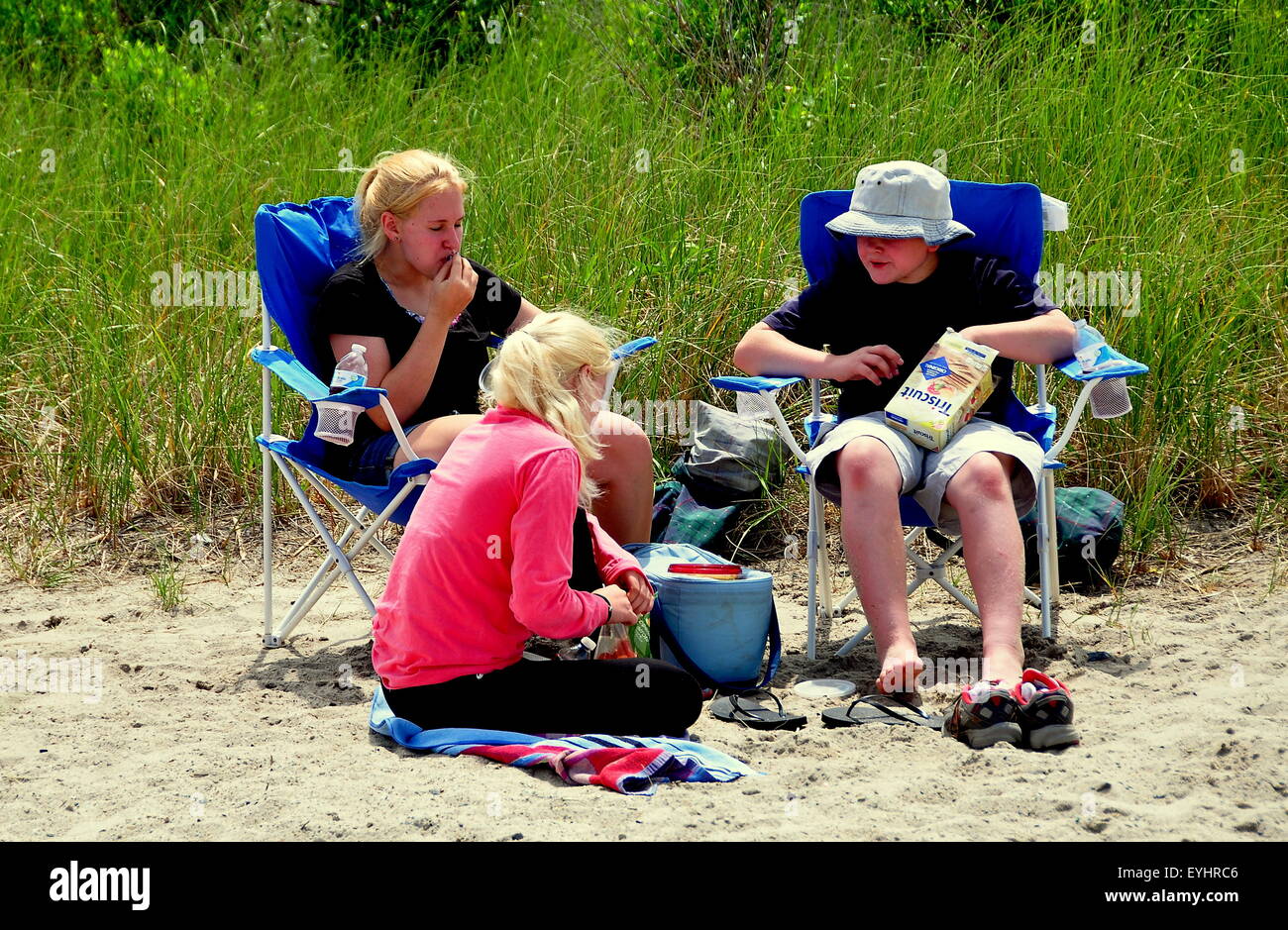 Orleans, Massachusetts : trois jeunes gens de détente sur le sable à côté de dunes herbeuses à RockHarbor Beach à Cape Cod Banque D'Images