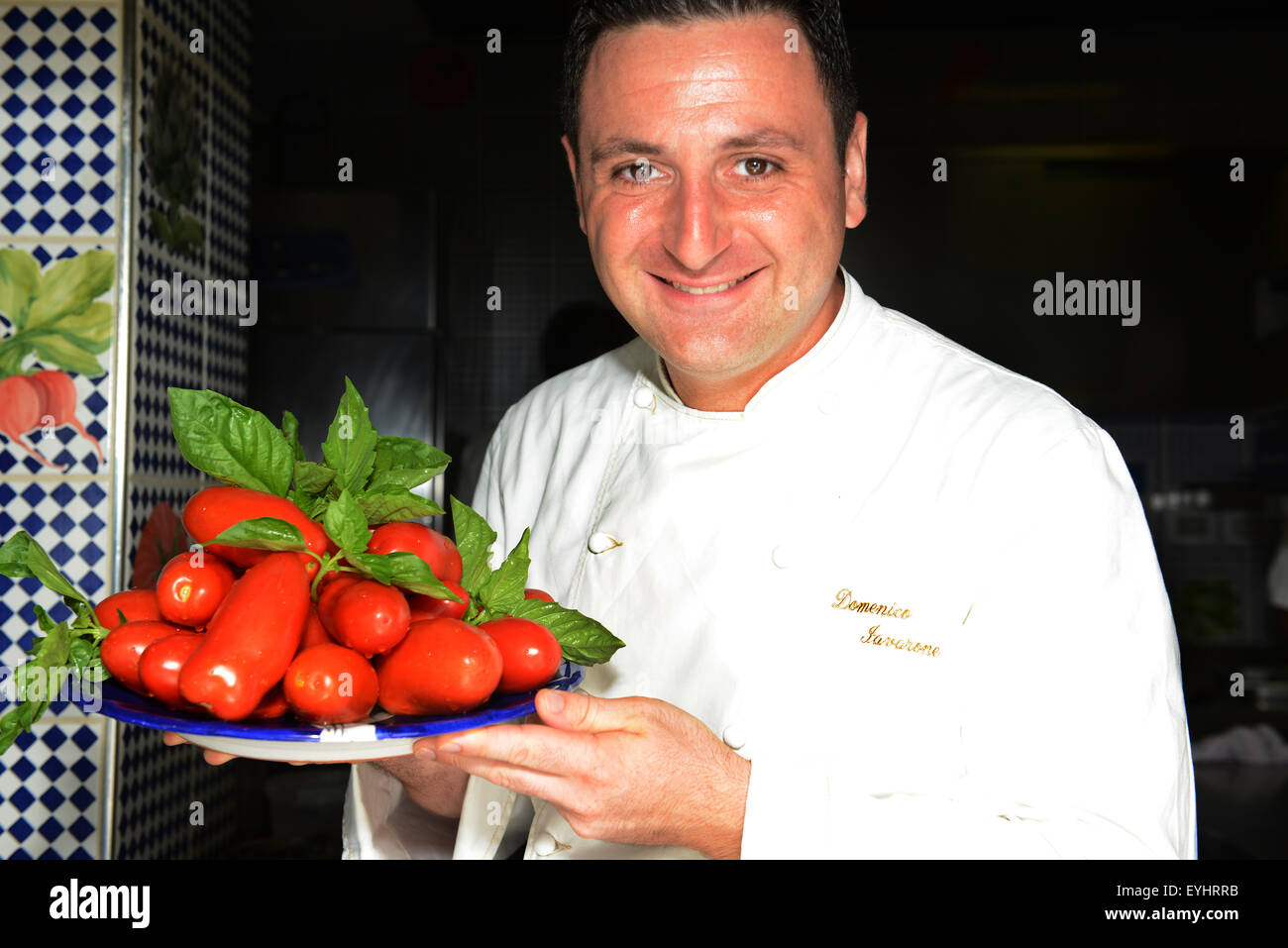 Chef de la Maxi Domenico Lavarone restaurant de l'Hotel CAPO LA GALA holding fresh tomates de San Marzano. Banque D'Images