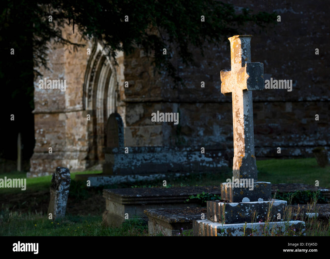 Pierre tombale croix éclairées par la lumière du soleil du soir. Banbury, Oxfordshire, Angleterre Banque D'Images