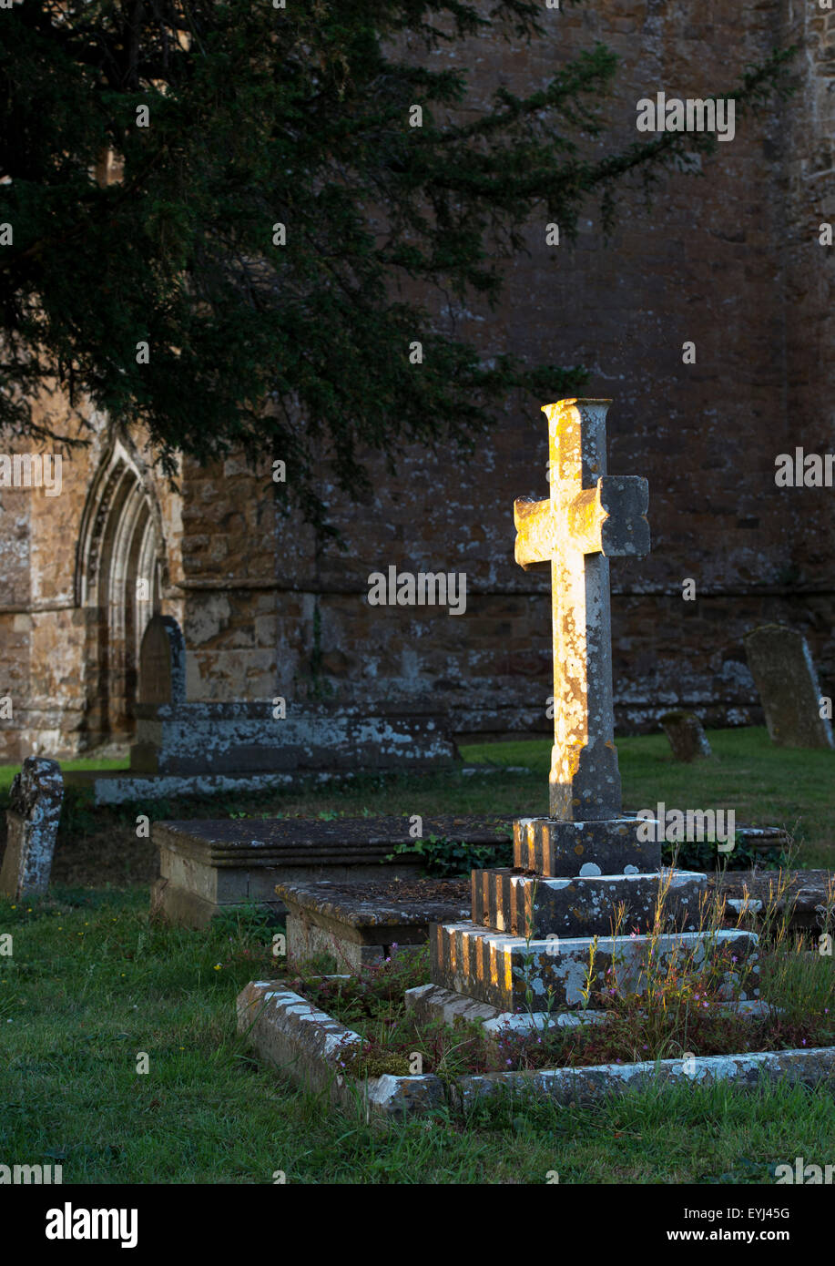 Pierre tombale croix éclairées par la lumière du soleil du soir. Banbury, Oxfordshire, Angleterre Banque D'Images