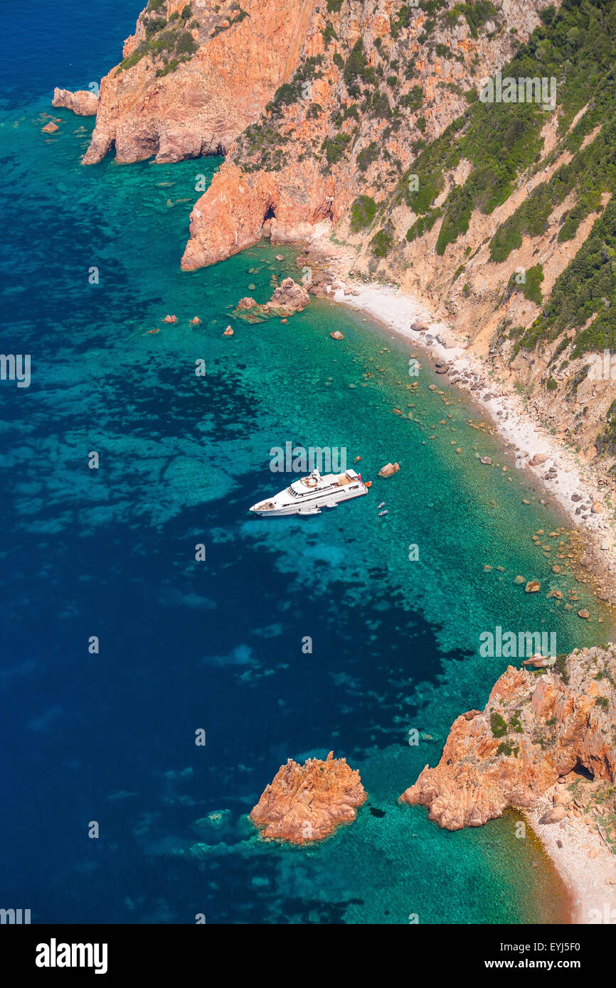 Luxury yacht de plaisance blanc ancré près plage rocheuse de l'île de Corse, photo verticale, birds eye view Banque D'Images