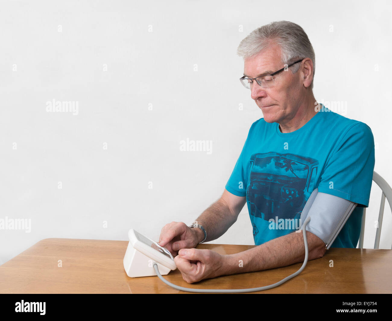Homme d'âge moyen en prenant les mesures de pression contre fond blanc à la hâte format horizontal Banque D'Images