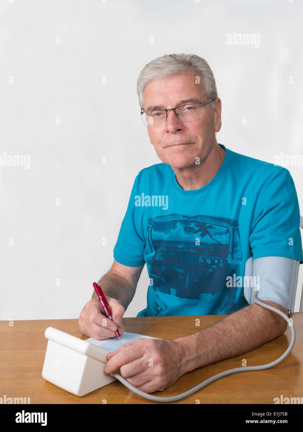 Homme d'âge moyen en prenant les mesures de pression fond blanc à la verticale vers la caméra et tourné à plaisir Banque D'Images