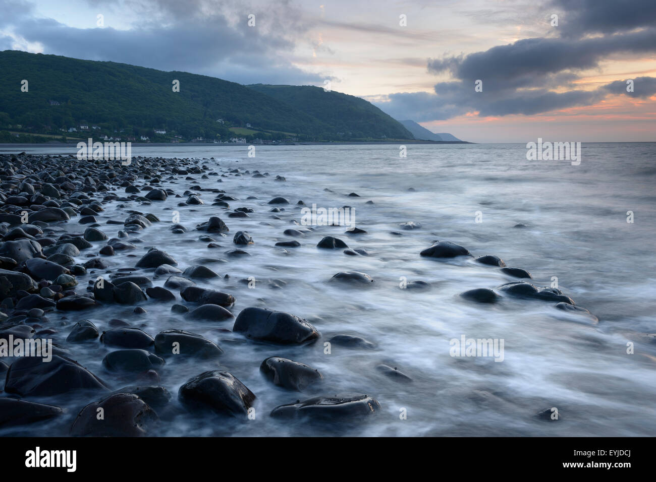 Coucher de soleil sur la plage de Bossington avec Porlock Weir et les collines au loin d''Exmoor. Banque D'Images