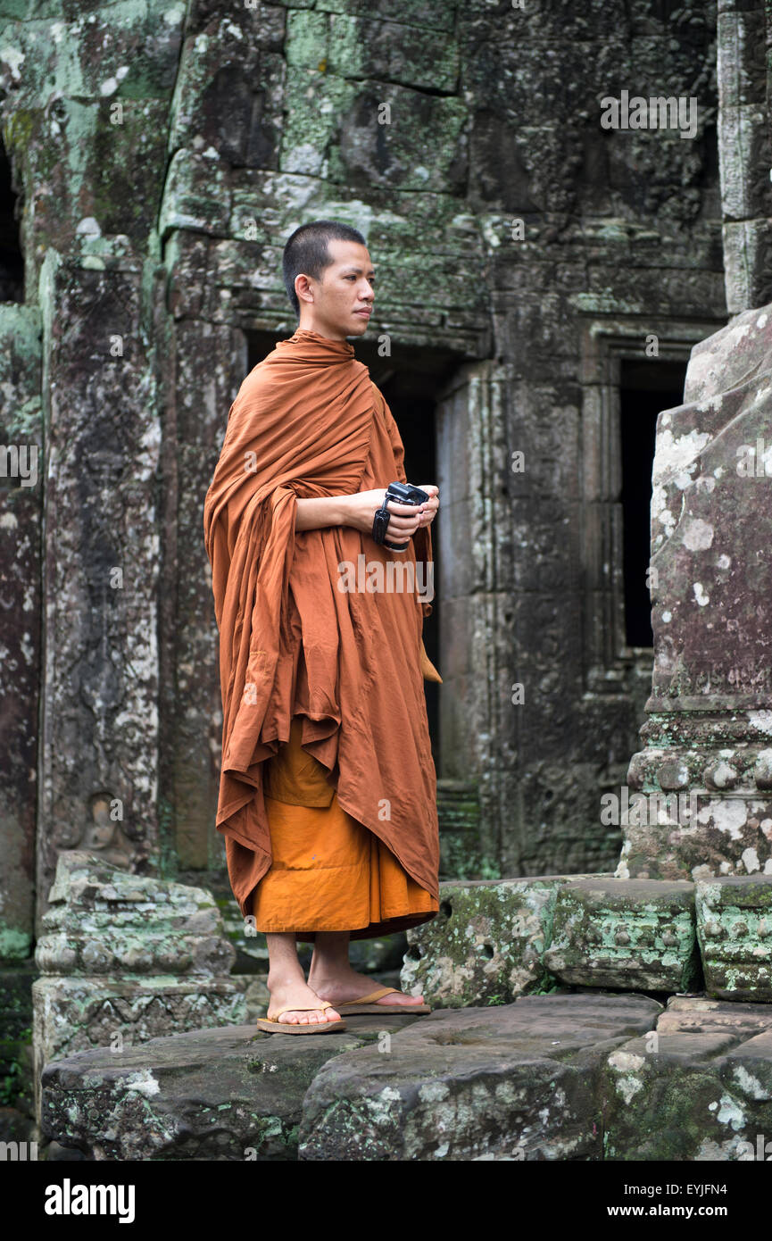 SIEM REAP, Cambodge - 30 octobre 2014 : le moine bouddhiste est parmi l'architecture de temple altérés à Bayon à Angkor Wat. Banque D'Images