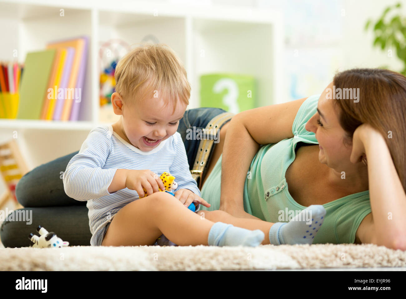 Heureux l'enfant jouet animal tient à jouer avec maman à la maternelle Banque D'Images