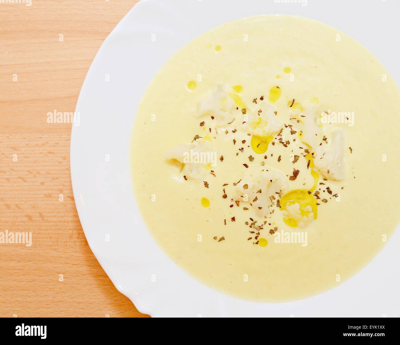 Vue de dessus sur la table avec la soupe crème de chou-fleur à l'huile d'olive, basilic herbes et petit ensemble de choux-fleurs. Banque D'Images Vue de dessus sur la table avec la soupe crème de chou-fleur à l'huile d'olive, basilic herbes et petit ensemble de choux-fleurs. Banque D'Images