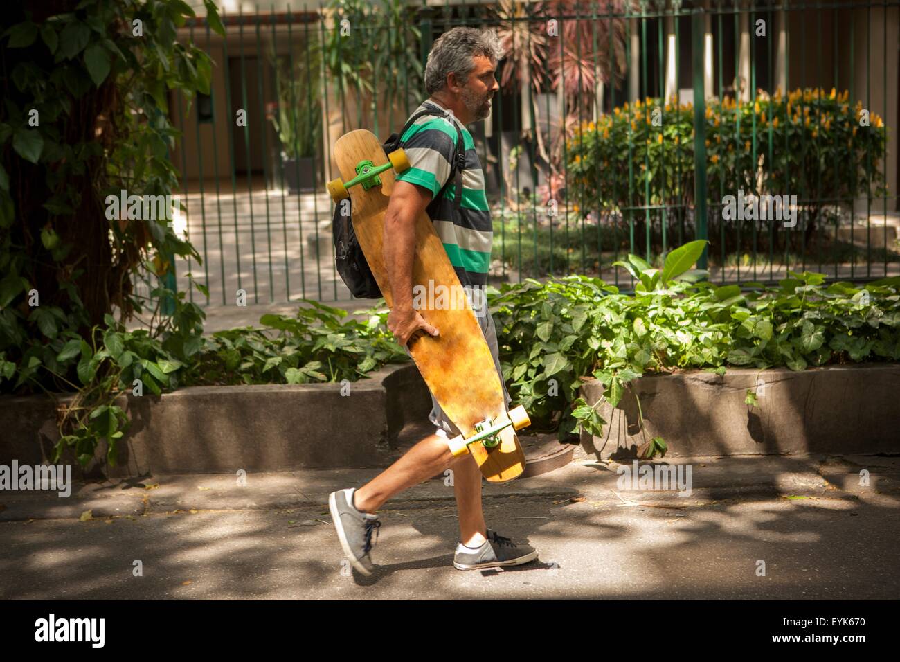 Homme mûr se promener sur un trottoir l'exercice de la planche à roulettes, de Rio de Janeiro, Brésil Banque D'Images