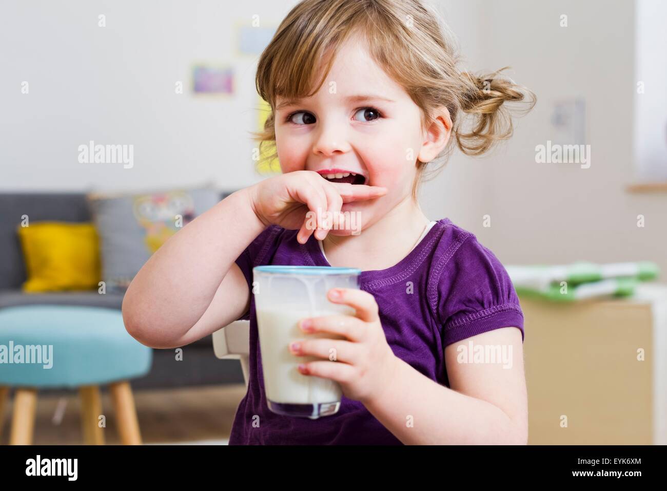Girl holding verre de lait à la maison Banque D'Images