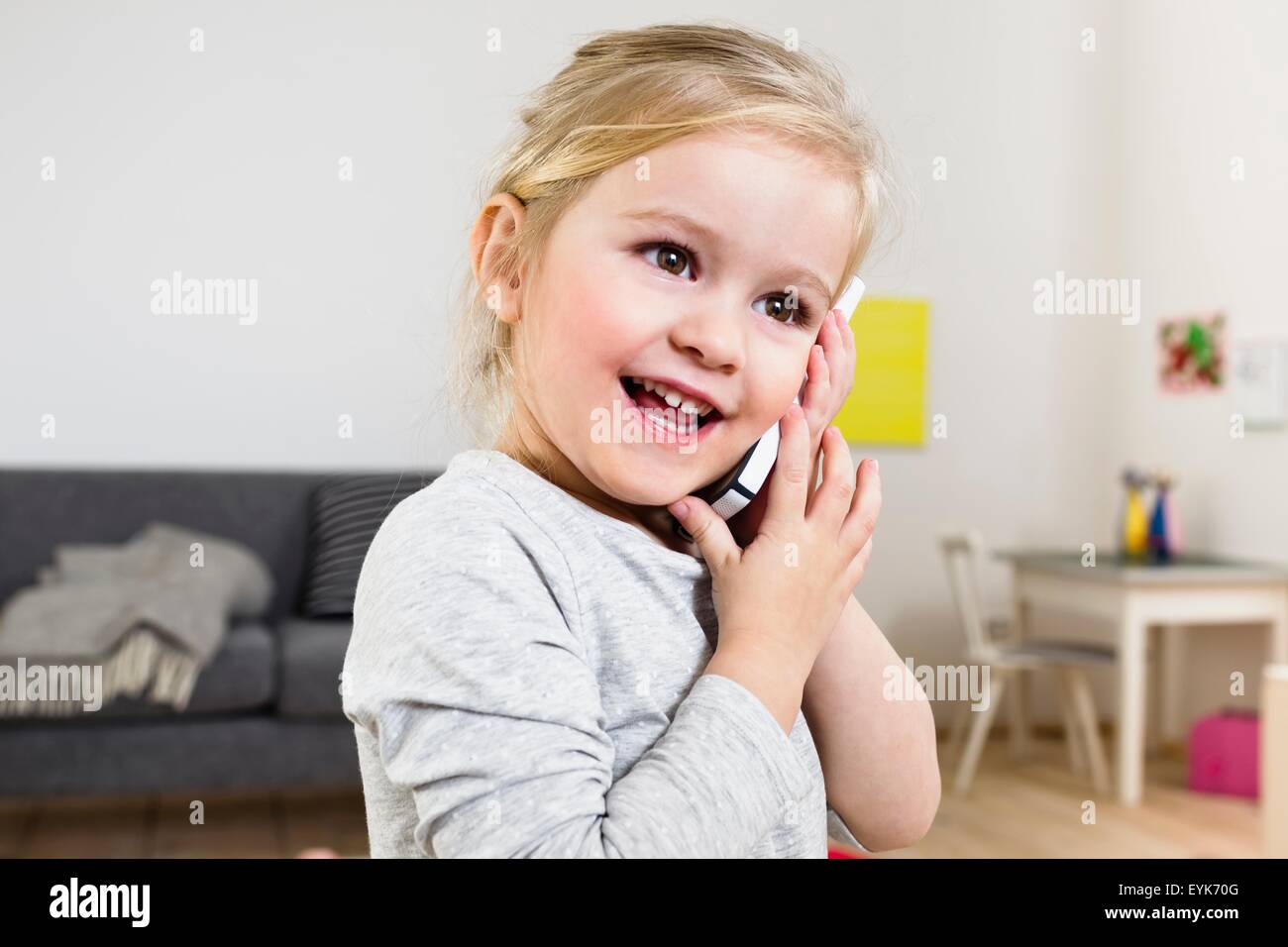 Girl talking on smartphone à la maison Banque D'Images