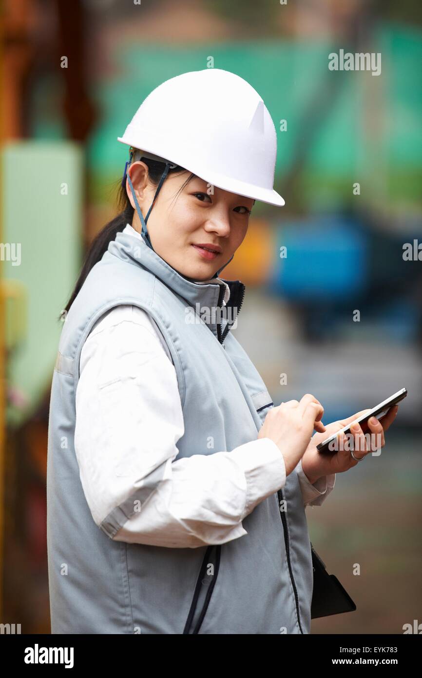 Portrait of worker using smartphone au chantier naval, GoSeong-gun, Corée du Sud Banque D'Images