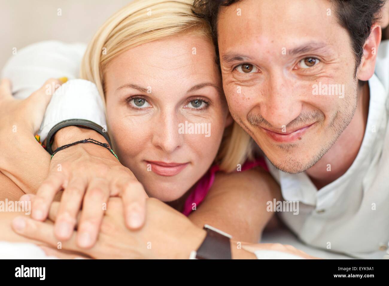 Portrait of mid adult couple, lying on bed, close-up Banque D'Images