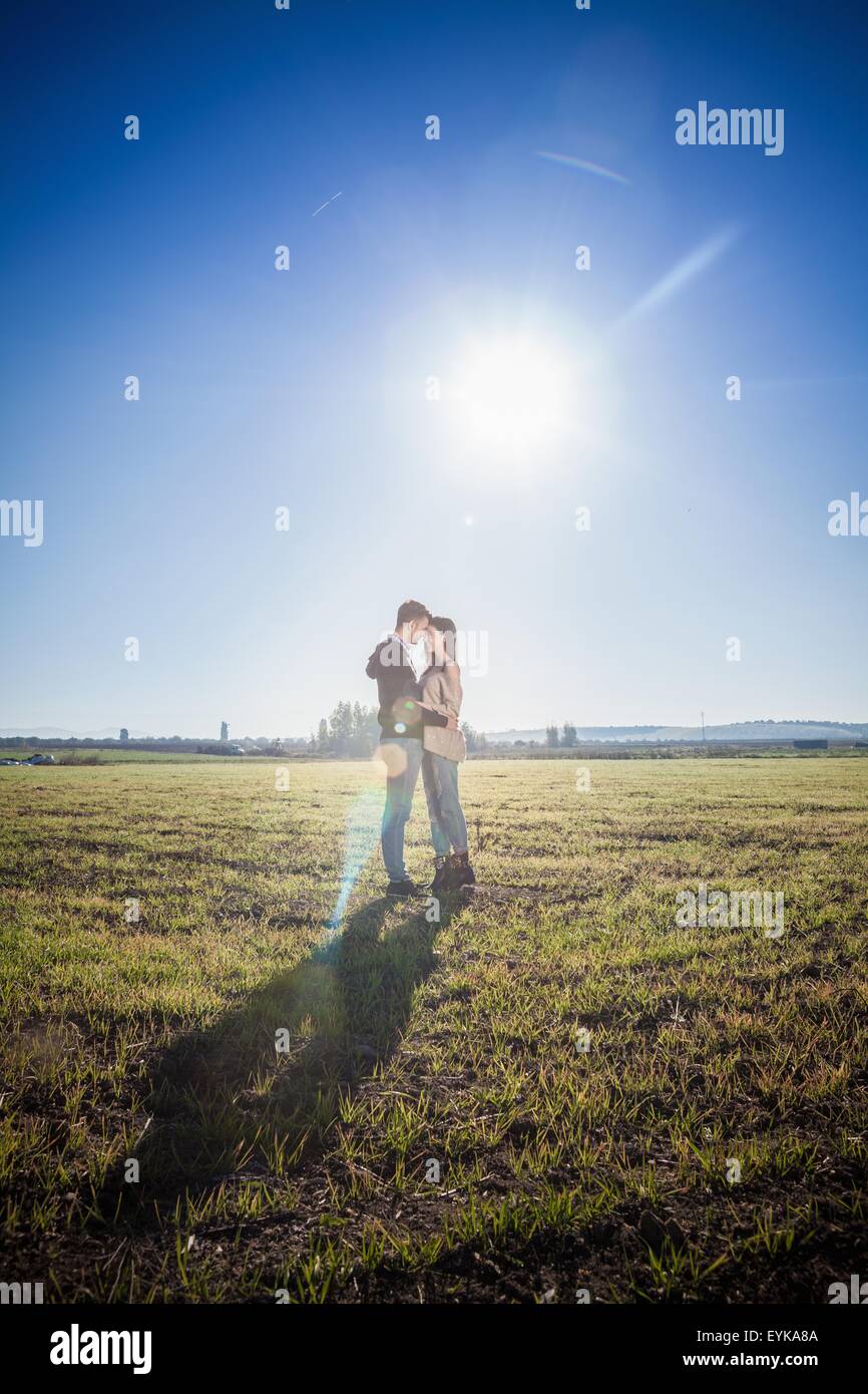 Jeune couple hugging in field Banque D'Images