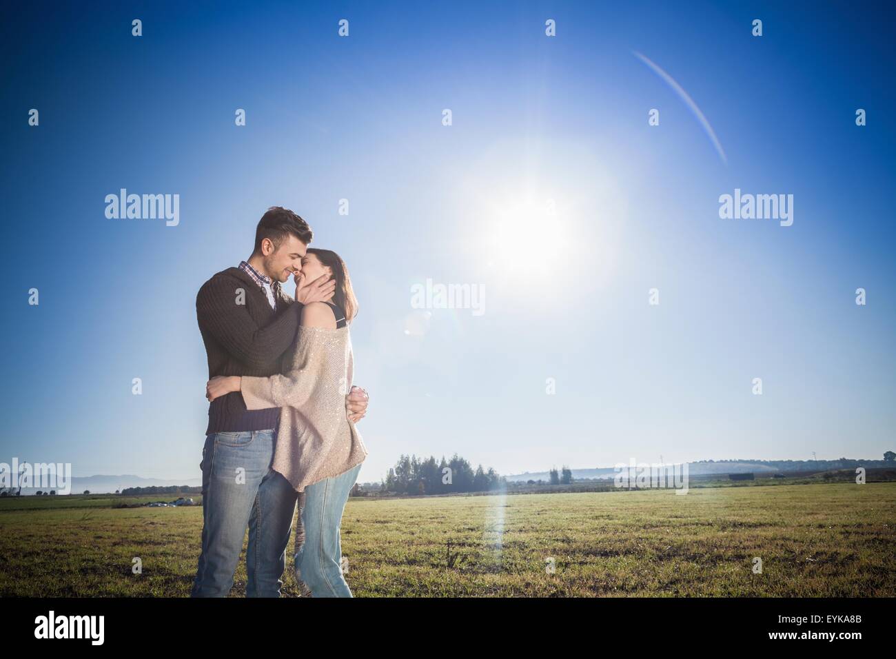 Jeune couple kissing in field Banque D'Images