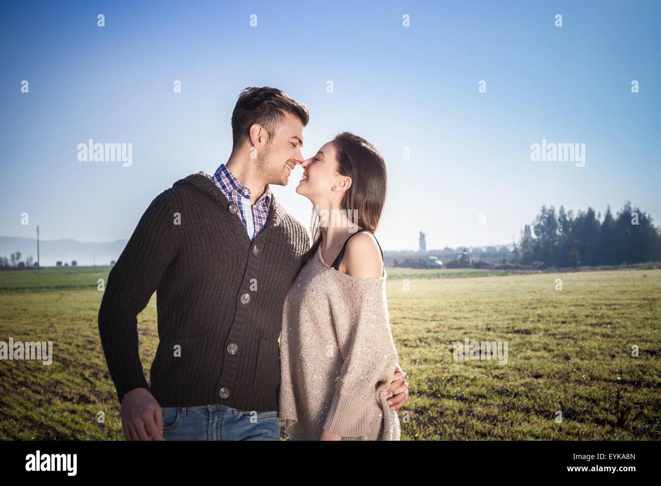 Jeune couple hugging in field Banque D'Images