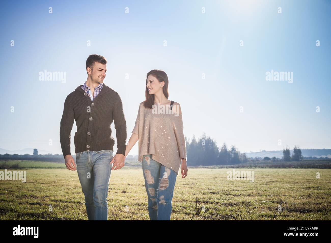 Jeune couple walking in field Banque D'Images