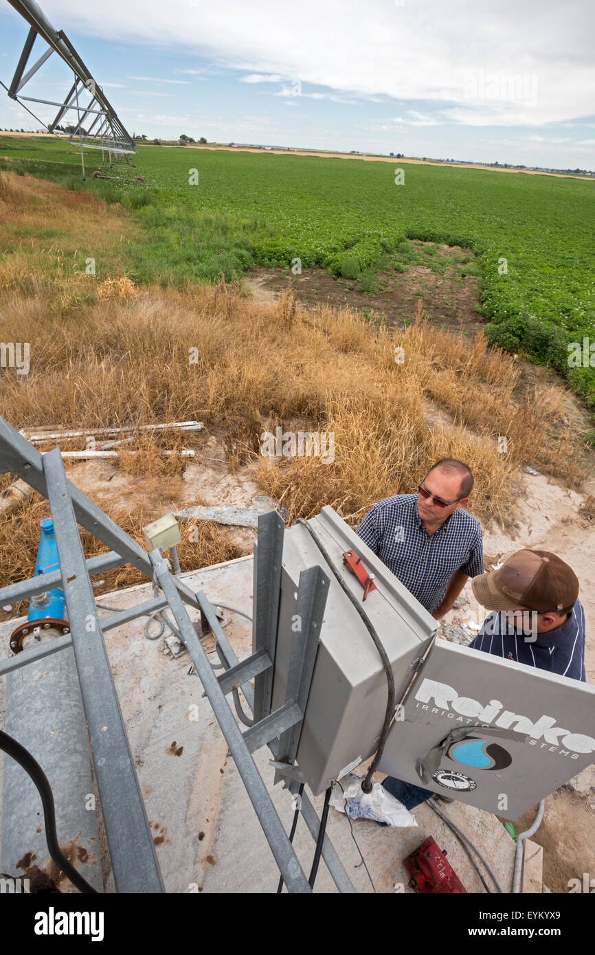 Shelley, New York - producteur de pommes de terre de l'Idaho Bryan Searle (à gauche) et son fils, Ray, réglez les commandes pour un centre d'irrigation à pivot-sys Banque D'Images