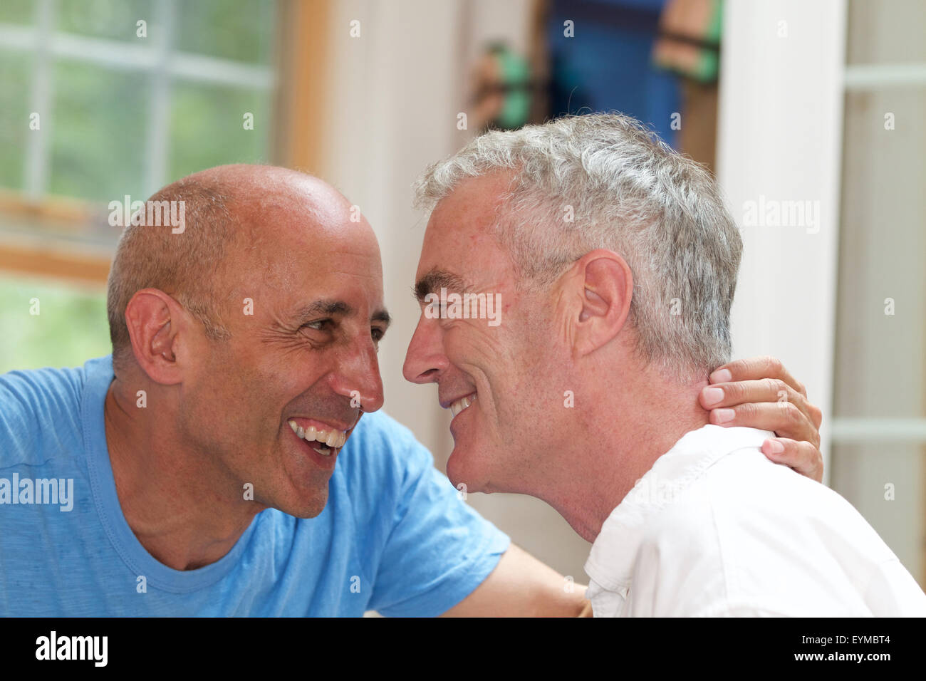 La haute couple gay en vacances étant affectueux, riant et souriant, au bed and breakfast Banque D'Images