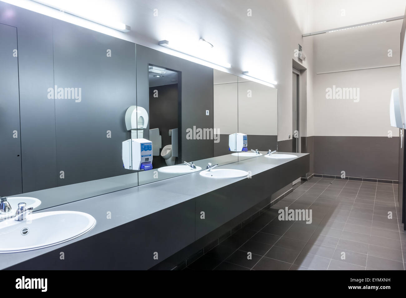 Dans les hommes il y a une grotte miroir sur le mur avec plusieurs lavabos Banque D'Images