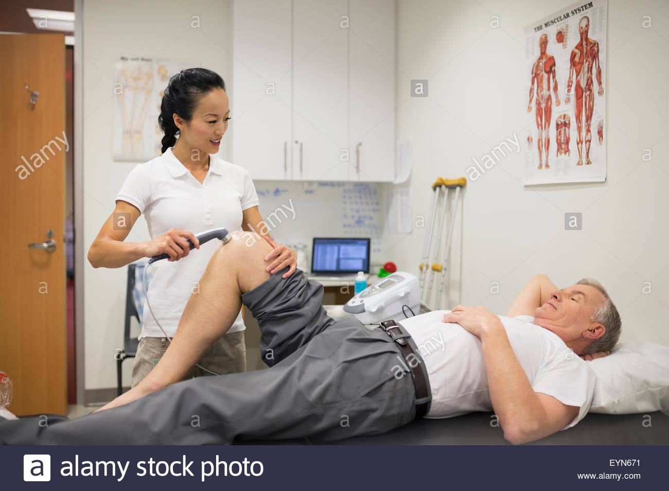 Thérapeute physique l'utilisation d'un capteur sur le genou du patient Banque D'Images