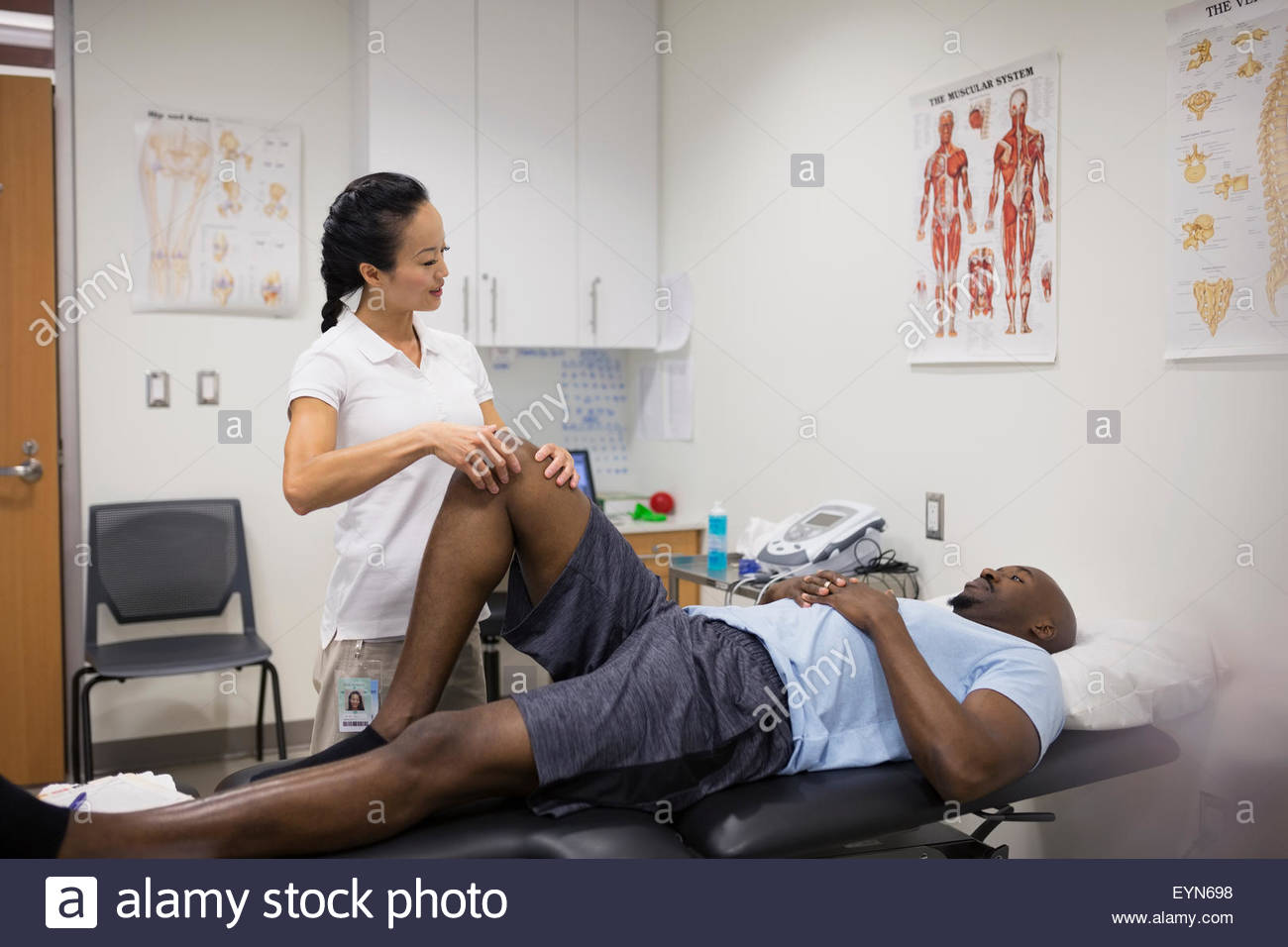 Le massage thérapeute physique du genou du patient en salle d'examen Banque D'Images