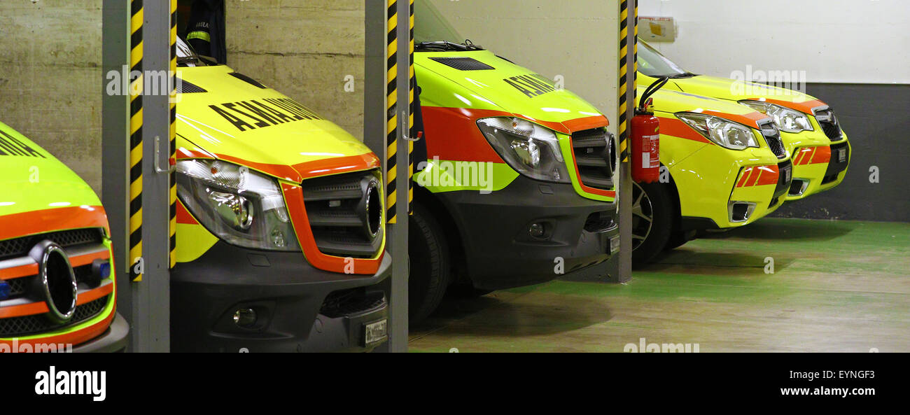 Ambulance jaune garée dans une ligne de véhicules d'urgence au cours de quart de nuit Banque D'Images