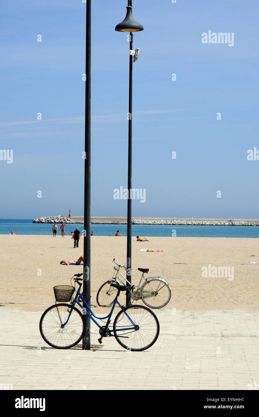 Deux vélos appuyé contre deux poteaux d'éclairage sur la plage. Banque D'Images