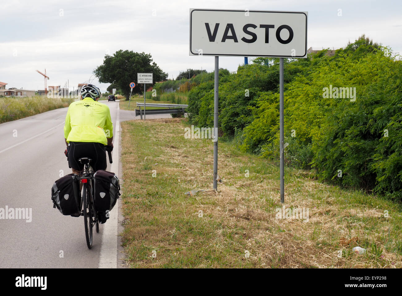 Un touring cyclist riding passé un panneau routier et d'entrer dans les limites de la ville de Vasto Banque D'Images