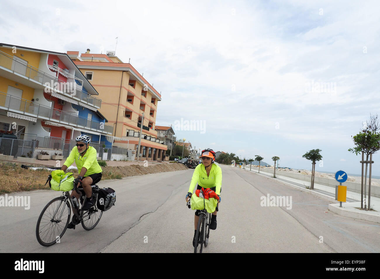 Deux cyclistes équitation leurs vélos sur une route près de la côte adriatique de l'Italie. Banque D'Images