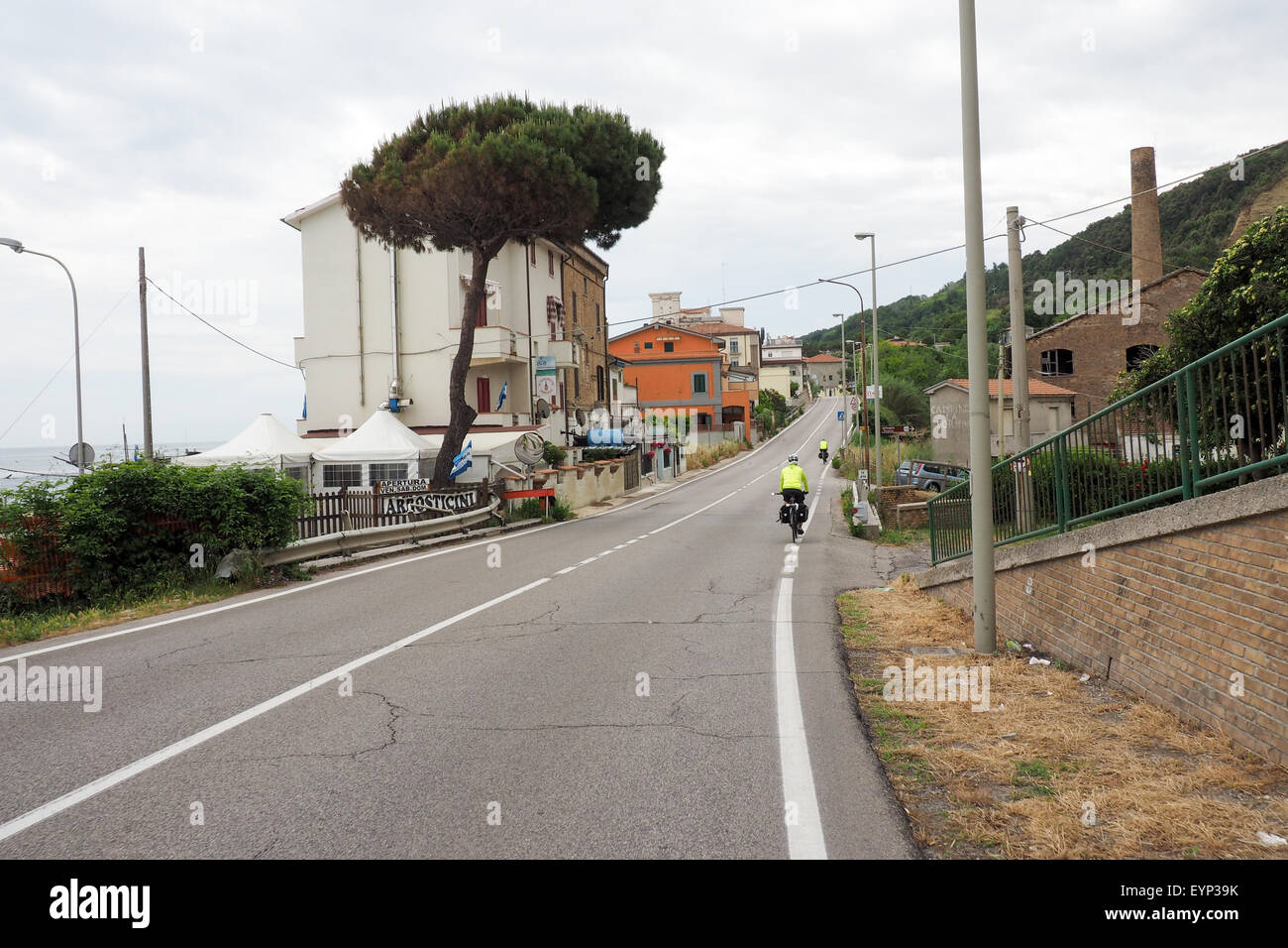 Deux cyclistes équitation leurs vélos sur la SS16 le long de la mer Adriatique dans les Abruzzes, en Italie. Banque D'Images