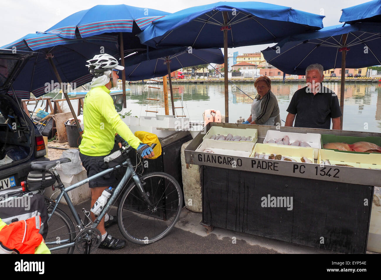 Une randonnée cycliste avec les marchands de vendre leurs prises de la journée sur le quai au port de Pescara. Banque D'Images