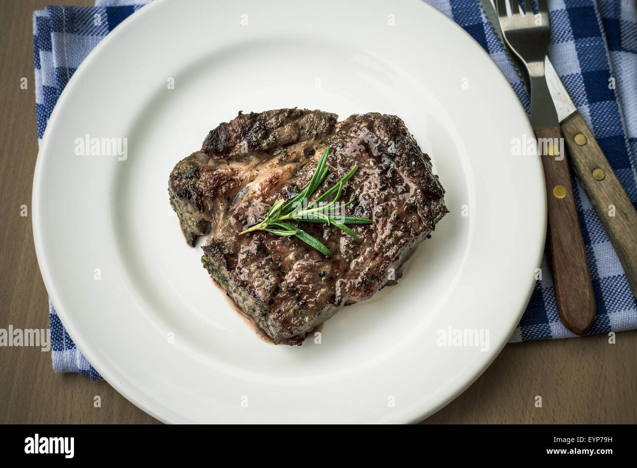 Bifteck de faux-filet grillé juteux avec couverts, vue d'en haut, aux couleurs rétro Banque D'Images