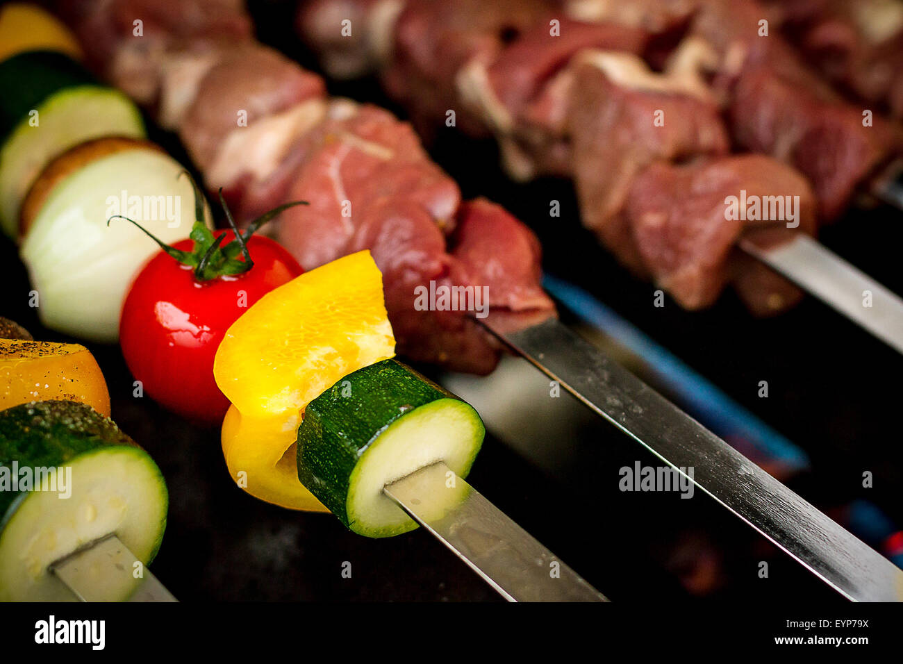 Des légumes et de la viande comme shish kebab sur grill à gaz, soft focus Banque D'Images