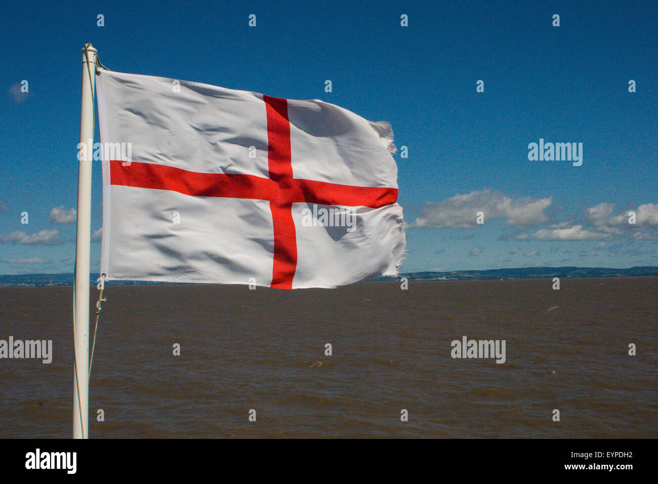 Drapeau anglais (St George's flag) voler dans le vent avec la mer derrière, Clevedon pier, Somerset, UK Banque D'Images