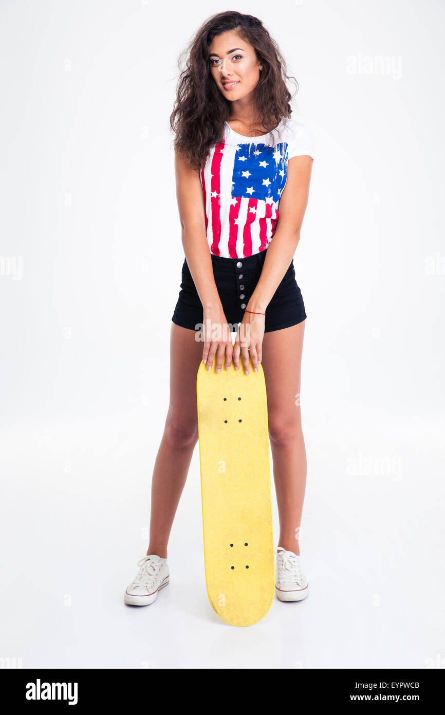 Portrait d'une belle teen girl holding skateboard isolé sur un fond blanc. Looking at camera Banque D'Images