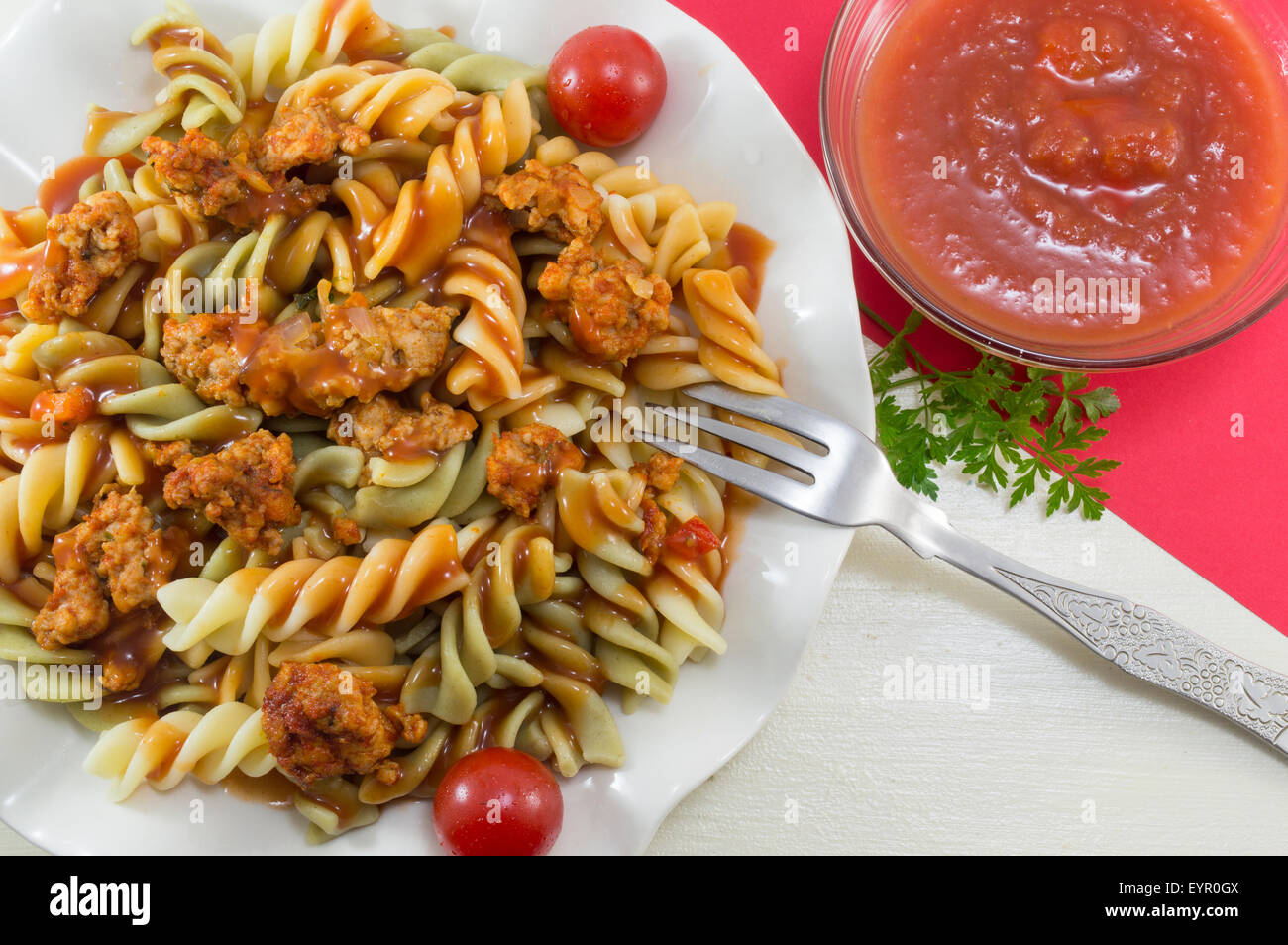 Pâtes de couleur avec la viande servie avec un bol de sauce tomate naturelle homamade Banque D'Images