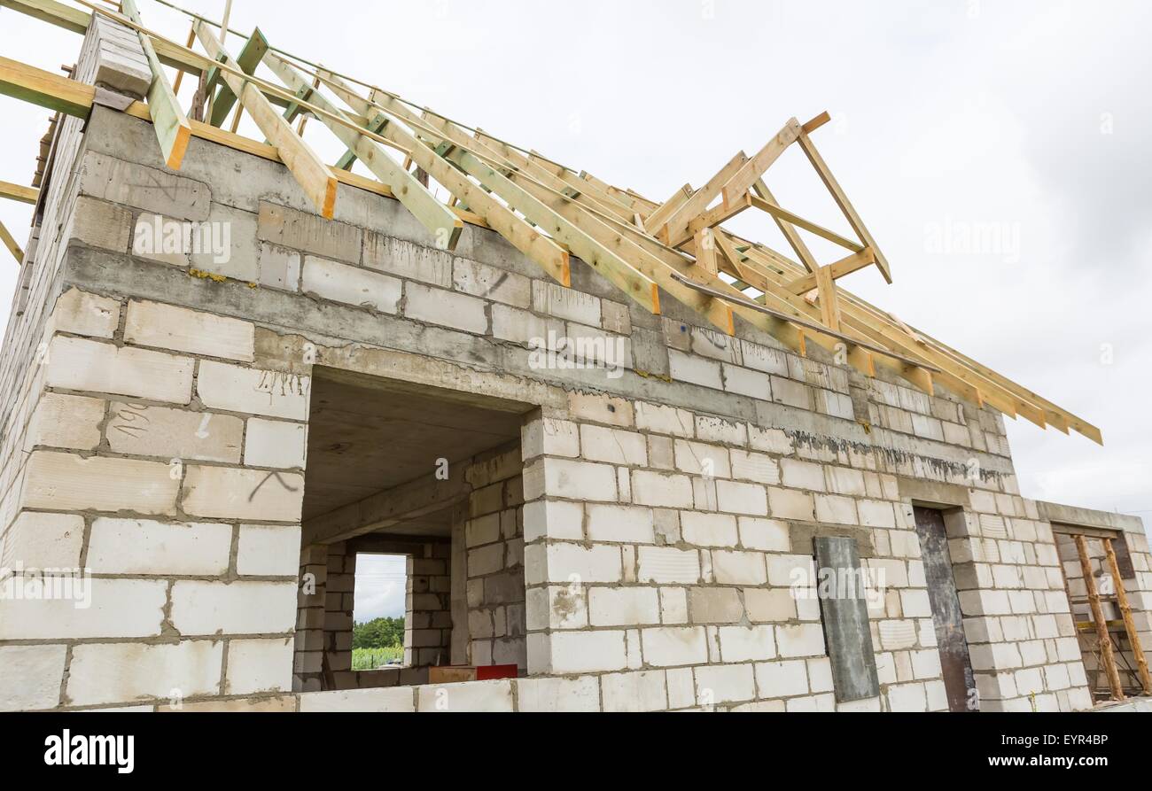 Maison inachevée en campagne. Partie de maison avec toit en bois de construction. La construction d'une maison au village (en Pologne Banque D'Images