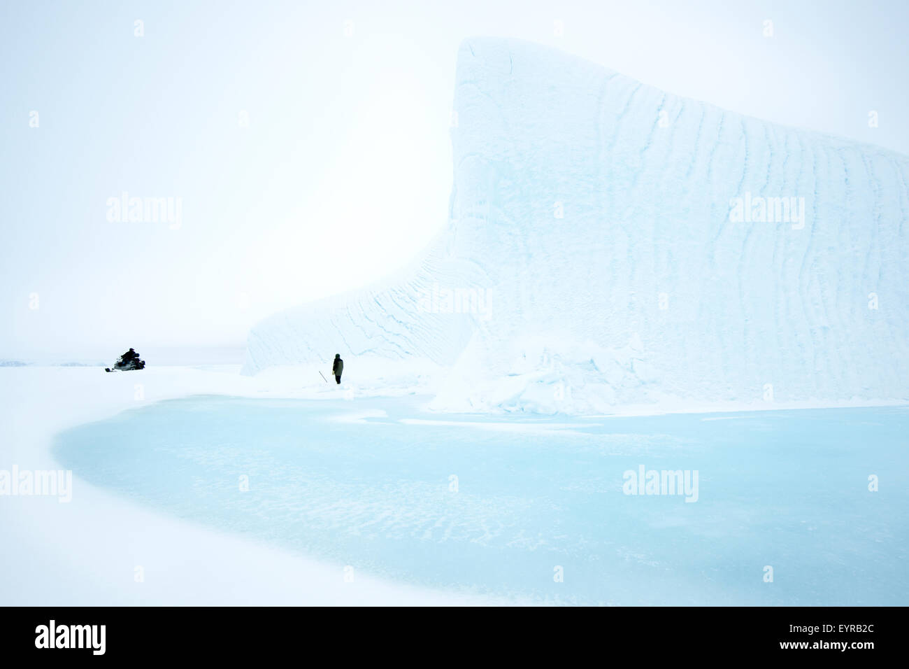 Guides inuit le transport de la glace pour l'eau potable à partir de la glace de mer congelés iceberg, banquise, la baie de Baffin, Nunavut, Canada. Banque D'Images