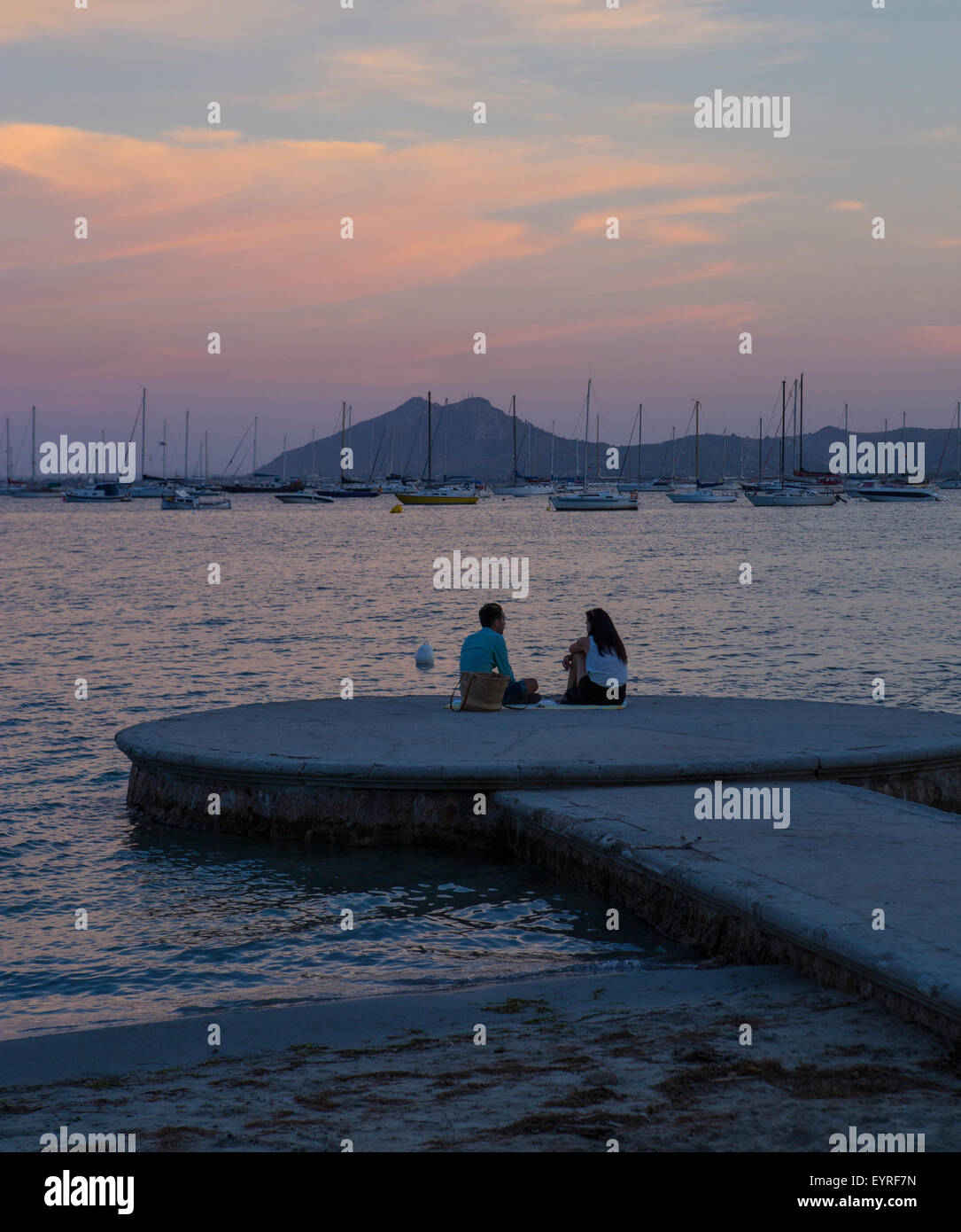 Couple romantique par la mer assis sur un jetti ayant un pique-nique romantique de Puerto Pollensa Banque D'Images