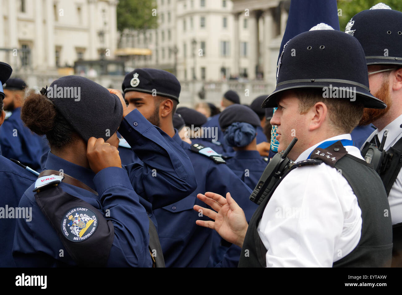 Londres, Royaume-Uni. 06Th Aug 2015. Un agent de police métropolitaine (à droite) vérifie le béret d'un Cadet de bénévolat (à gauche) lors d'un défilé à Trafalgar Square, Londres. L'événement de payer grâce à l'Cadets était le premier du genre le 3 août 2015. Crédit : Paul Grove/Alamy Live News Banque D'Images