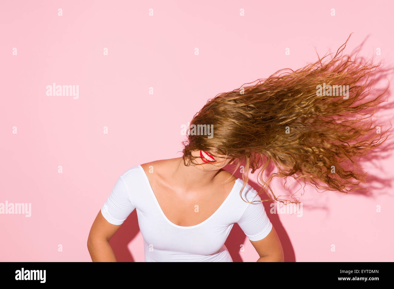 Jeune femme, tête, cheveux, mouvement, fond rose, Banque D'Images