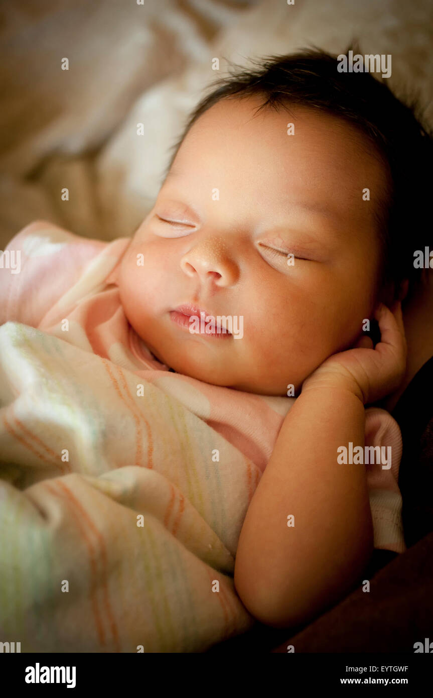 Bébé nouveau-né enveloppé dans une couverture de dormir sur son dos. Banque D'Images