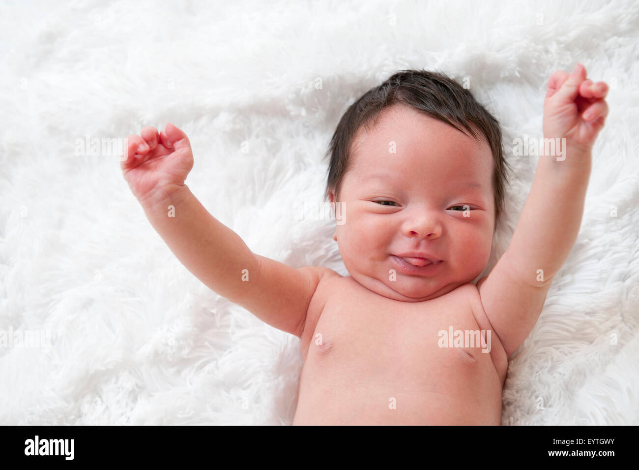 Heureux bébé nouveau-né avec les bras en l'air. Banque D'Images