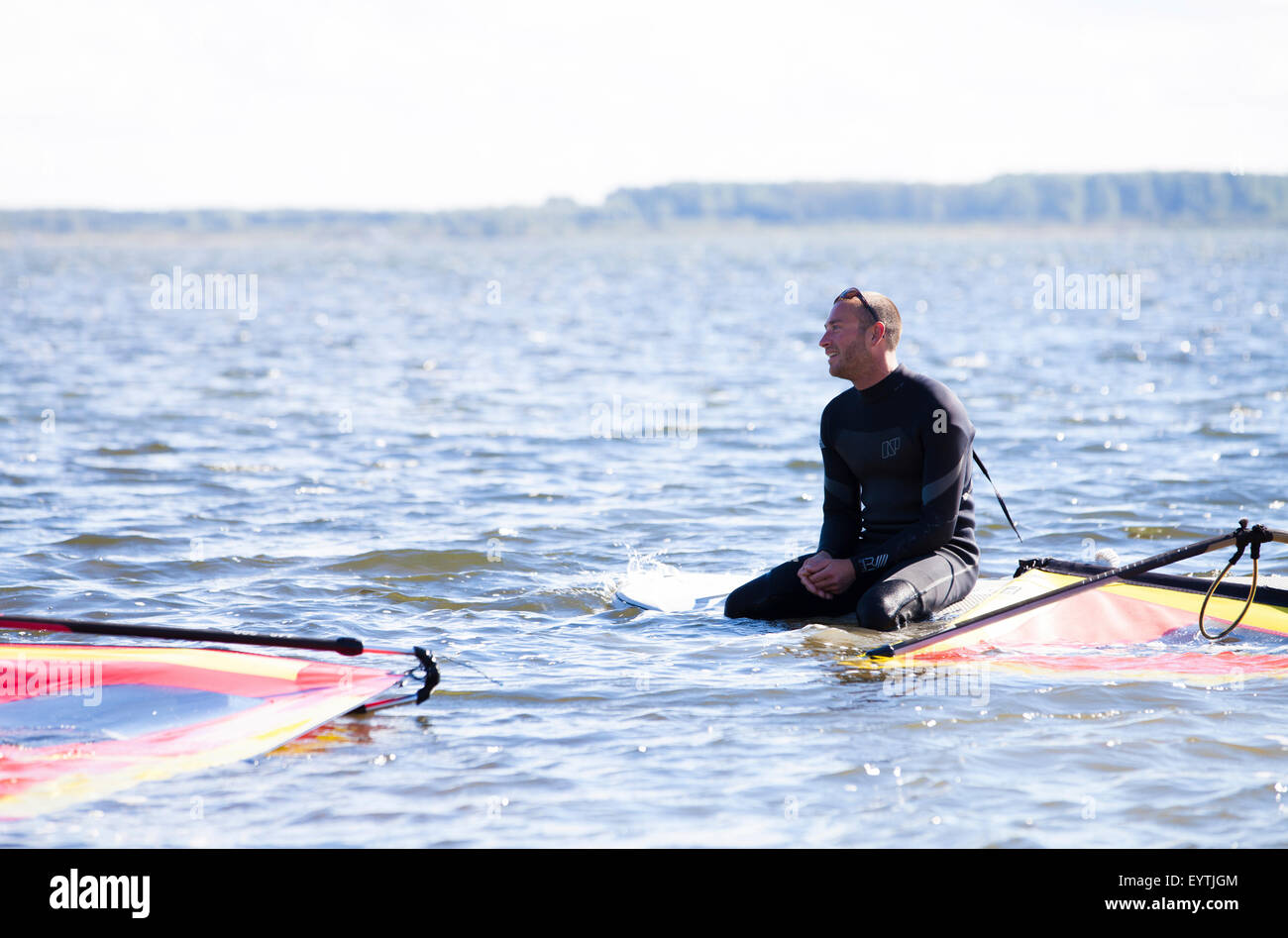 Des cours de surf, wind surf enseignant expliquer quelque chose à ses collégiens sur l'eau Banque D'Images