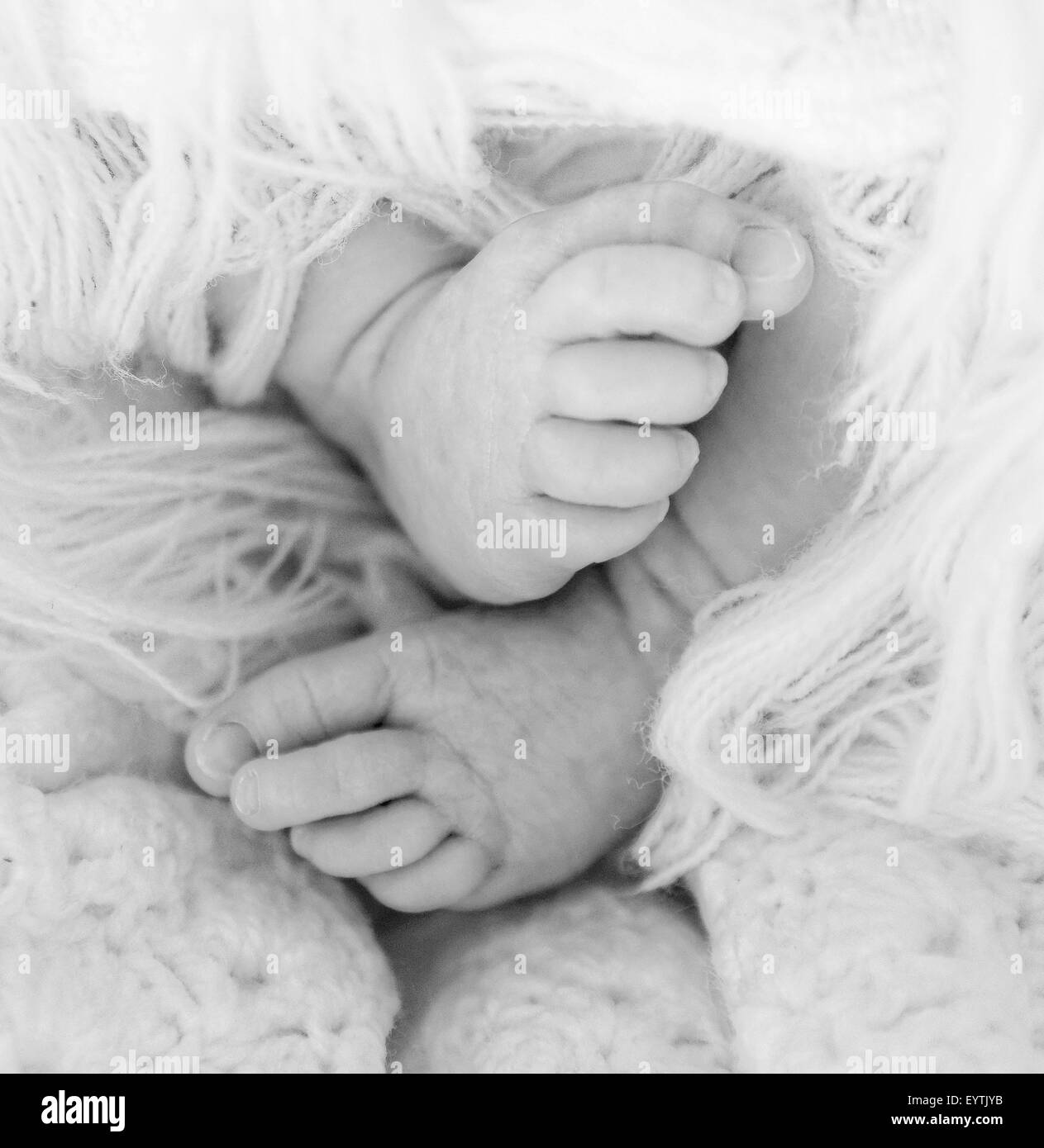 Un nouveau-né de curling les pieds sous un châle Banque D'Images