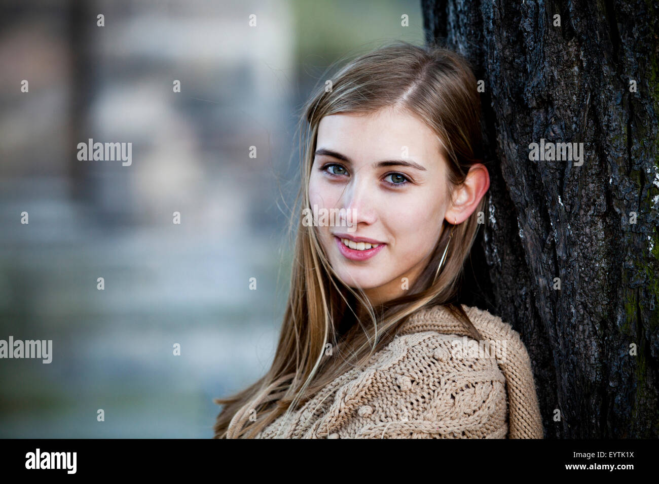 Souriante jeune femme contigu à un arbre Banque D'Images