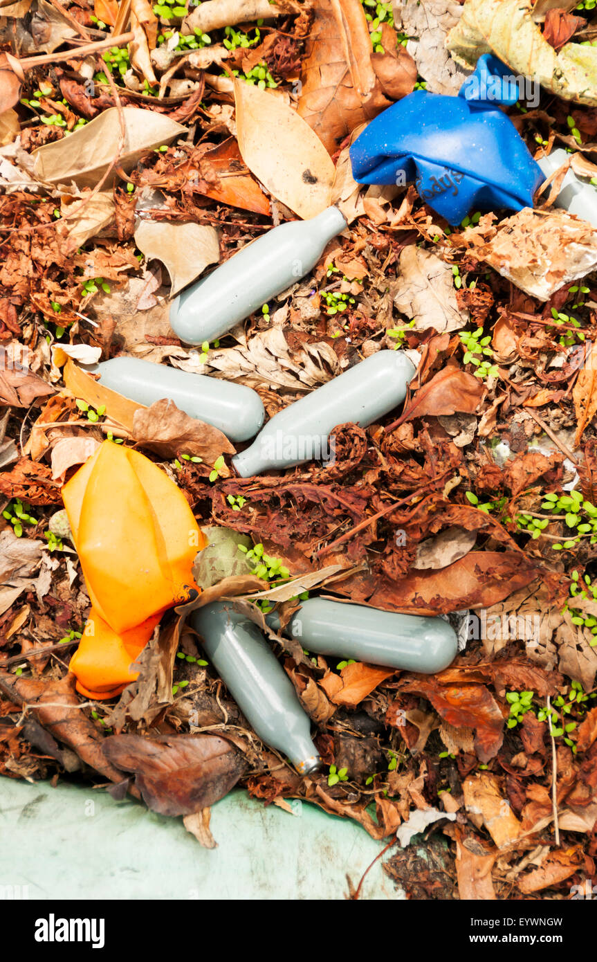 Contenants vides et des ballons utilisés pour l'inhalation d'oxyde nitreux haut juridique abandonné à côté d'une route de campagne. Banque D'Images