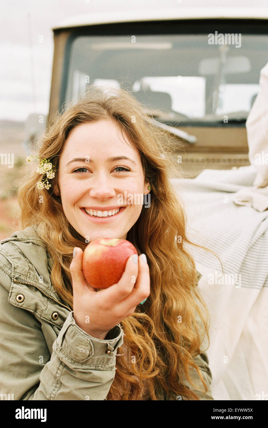 Une jeune femme tenant une peau rouge apple. Banque D'Images Une jeune femme tenant une peau rouge apple. Banque D'Images